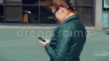 年轻女子在街上打字发<strong>手机短信</strong>，在城市里散步。